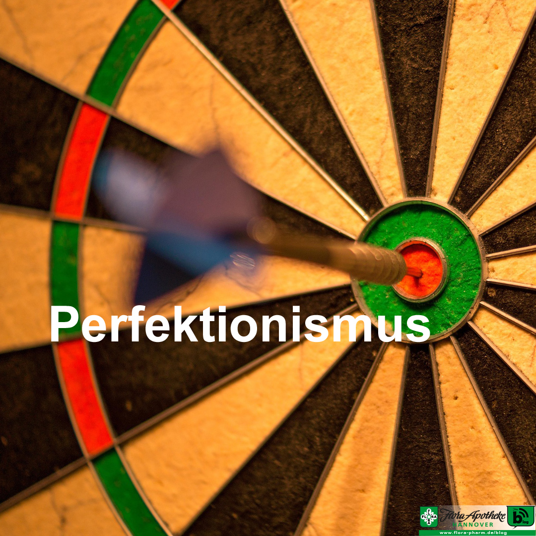 perfektionismus Ein Dartpfeil steckt in der Mitte des Bullseye als Visualisierung von Perfektionismus - erstrebenswert oder zu viel