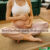 Eine schwangere Frau im Schneidersitz hält ihren Babybauch, der Text im Bild lautet: Streifenfrei zum Babyglück