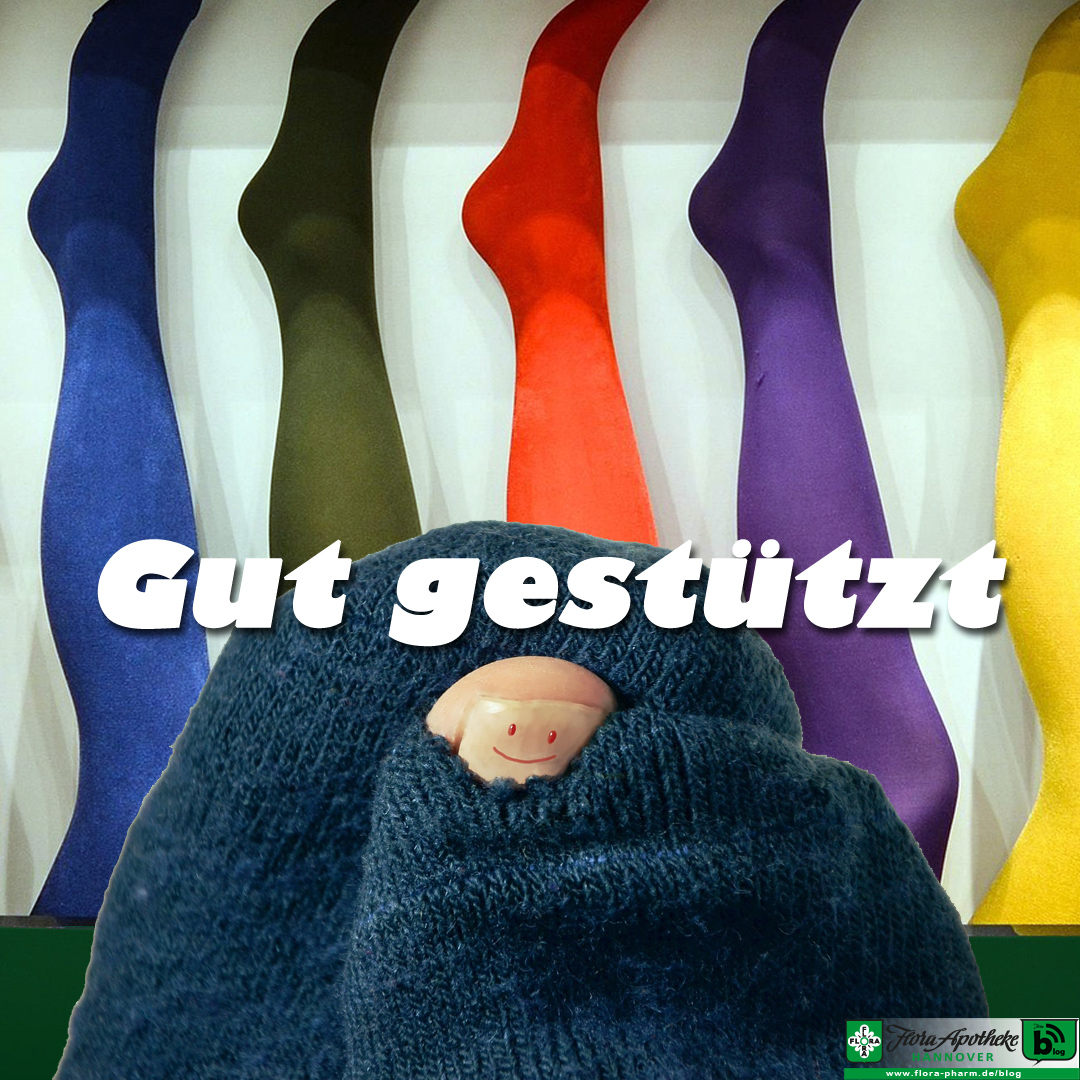 Gut gestützt - Es geht um Kompressions- oder Stützstrümpfe. Im Vordergrund ist noch ein kaputter Strumpf, aus dem der große Zeh guckt. Auf dem Nagel ist ein Siley aufgemalt.